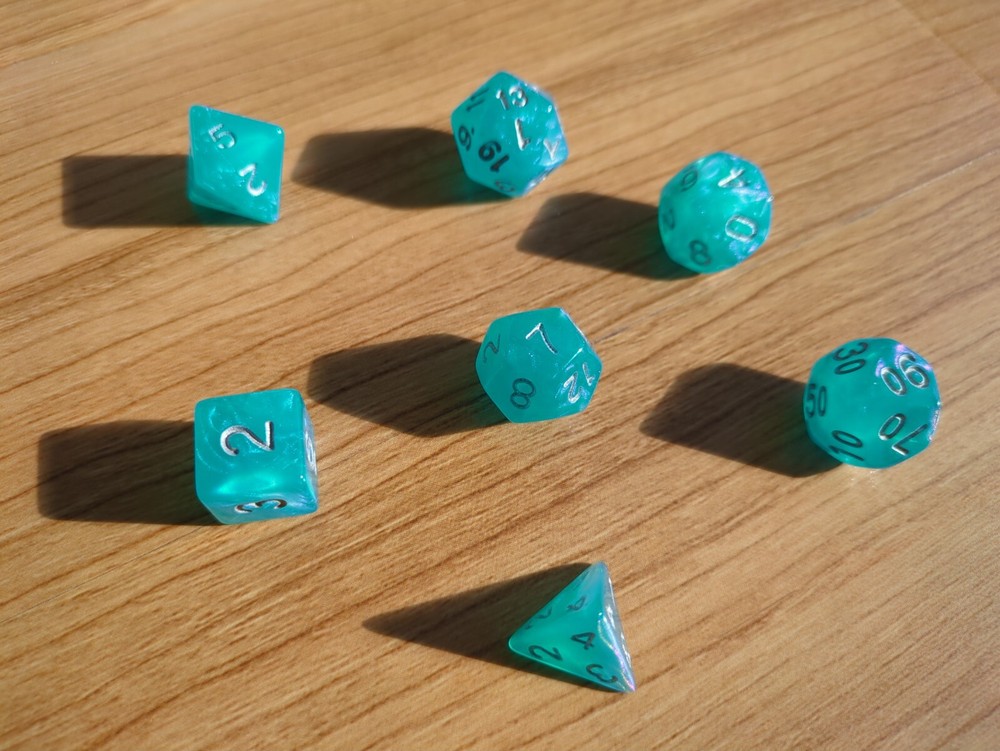 set of 7 dice, semi-transparent blue shimmer with silver numbers