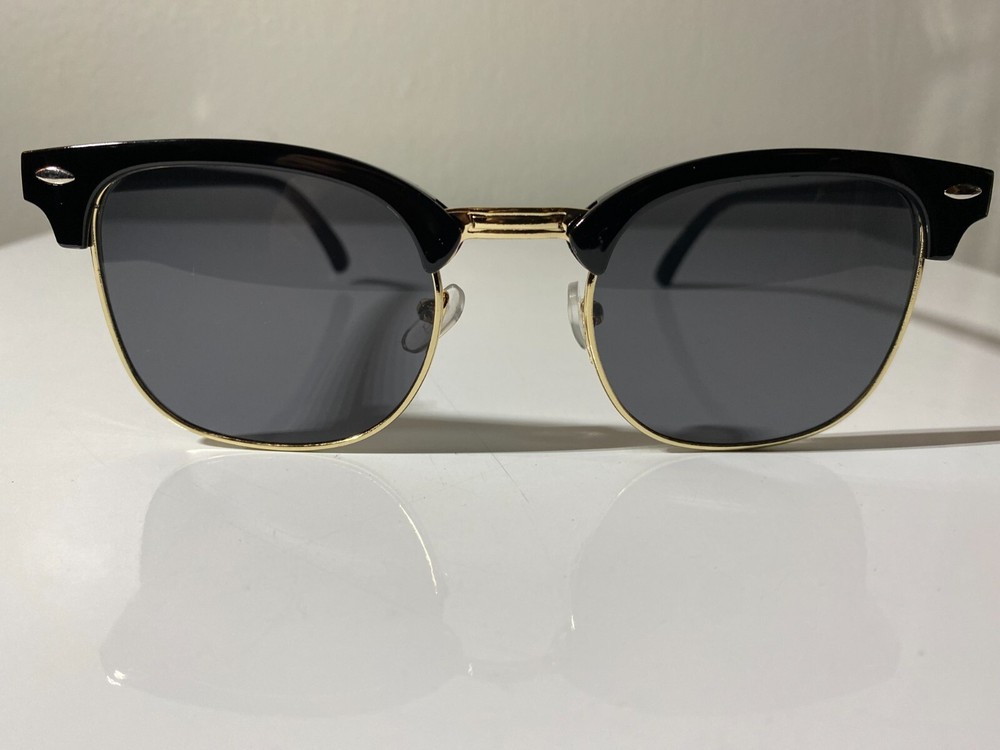 Malcolm X style black and gold frame sunglasses with dark lenses