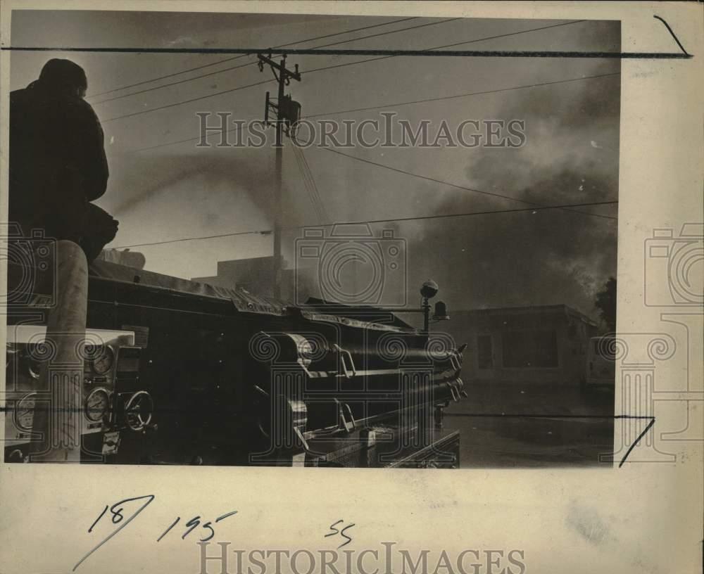 1973 Press Photo Firefighter Aims Hose From Atop Truck Into Large Building Fire