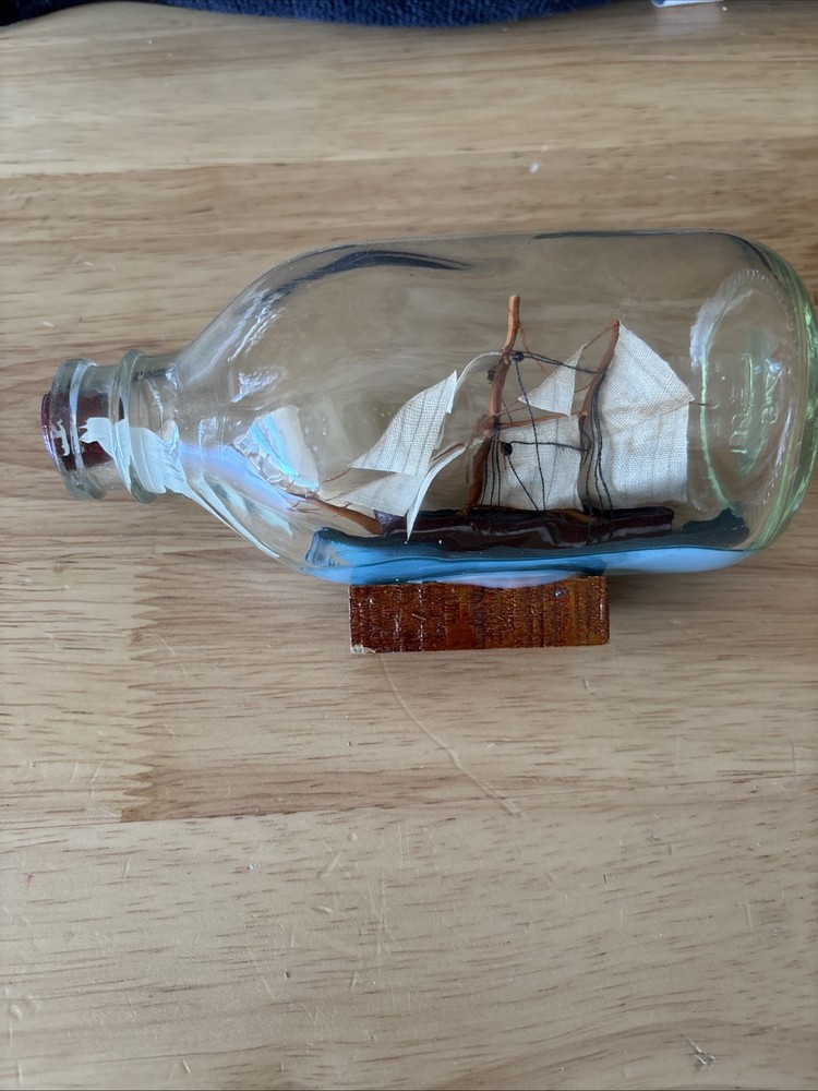 Vintage Ship in a Glass Bottle On Wooden Stand