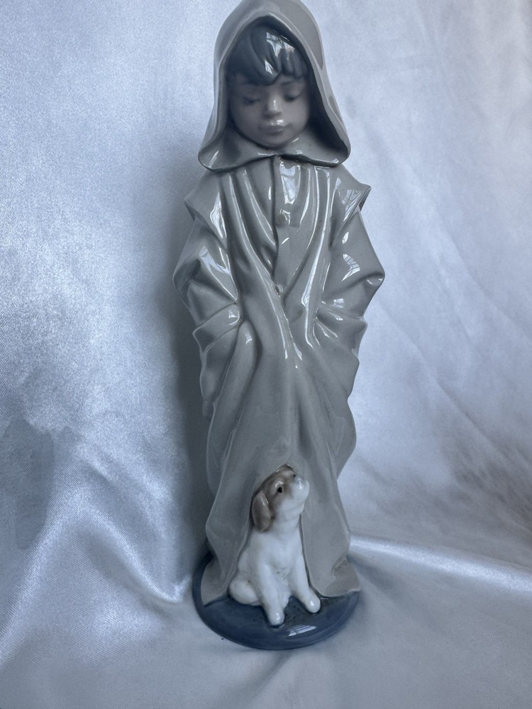 Rare figure of a boy in a raincoat walking a dog by NAO-Lladro, Porcelain, Spain