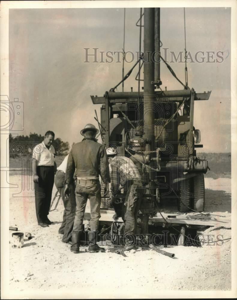 1964 Press Photo Workmen Handle Pipe at Mouth of New Well - lrx55408