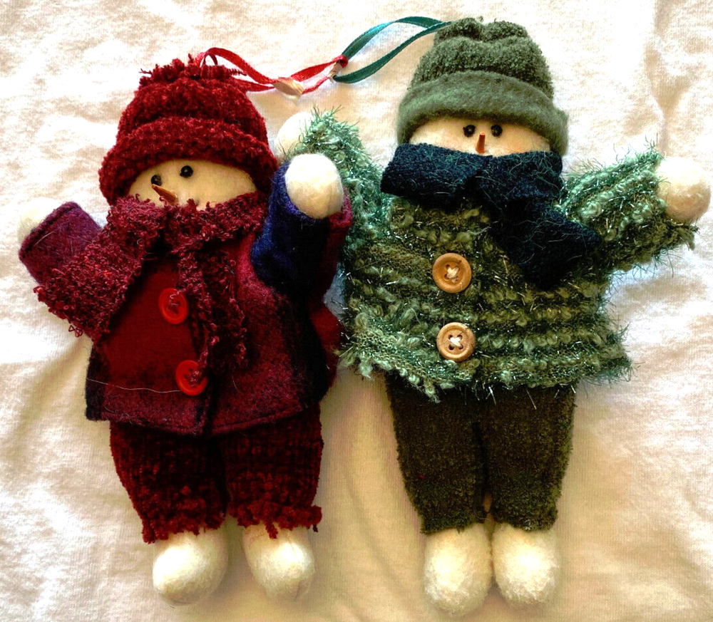 2 cute snowmen or snowwomen with knitted hats, scarves, pants and shirts.
