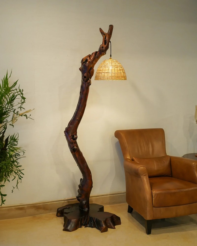 This is a modern floor lamp made of wood with a warm light color.