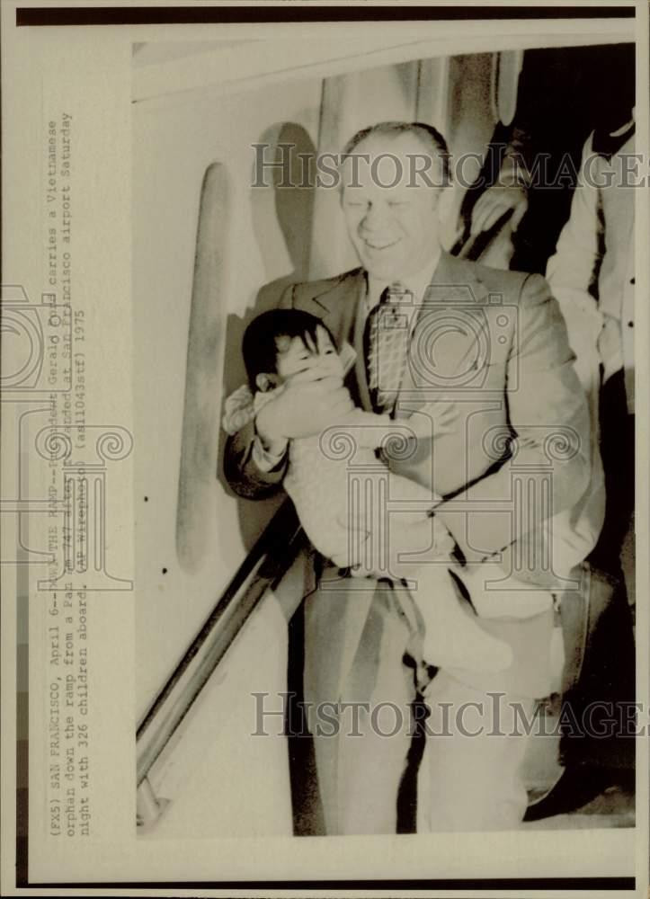 1975 Press Photo Gerald Ford carries Vietnamese orphan at San Francisco Airport