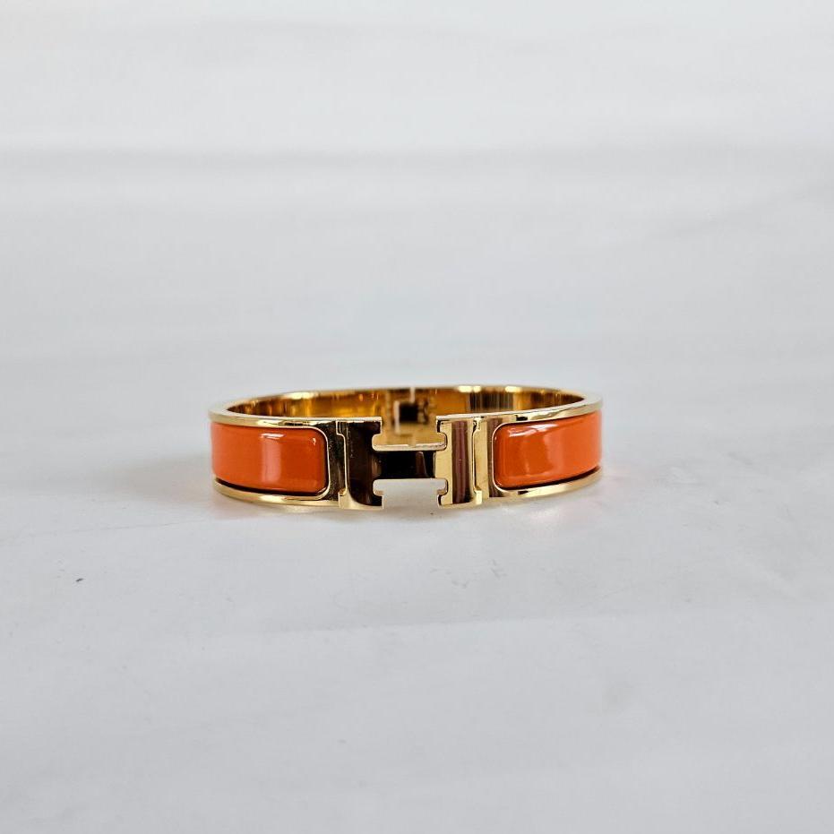 Hermès Clic Clac Gold Bangle with Vibrant Orange Enamel