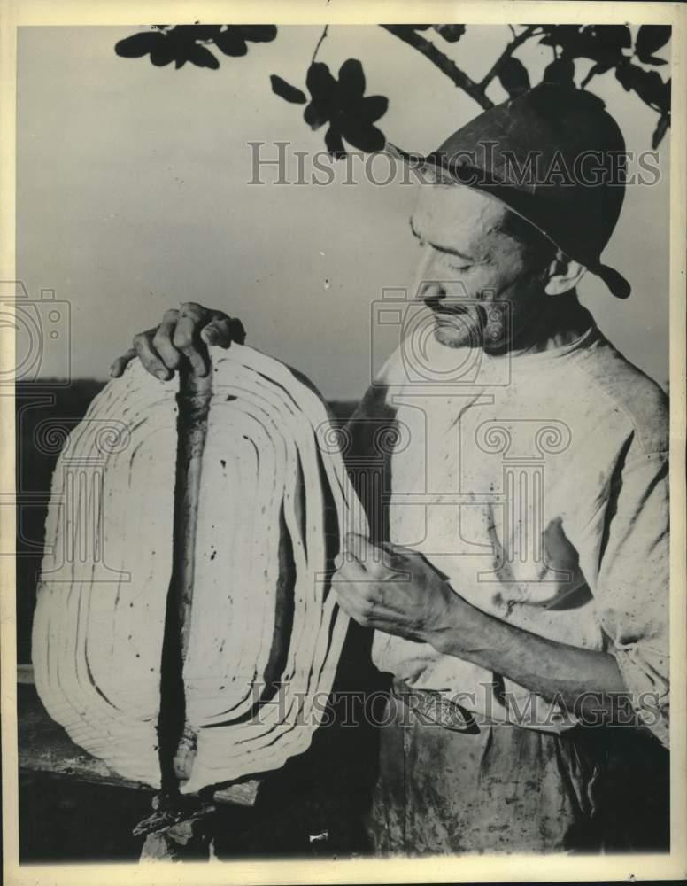 Press Photo Rubber plantation worker with crude rubber ball in Brazil